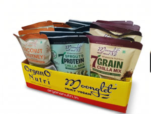 Assorted Moonglit snack bags in a yellow box showing vegan Chilli Mix and other flavors with bright packaging
